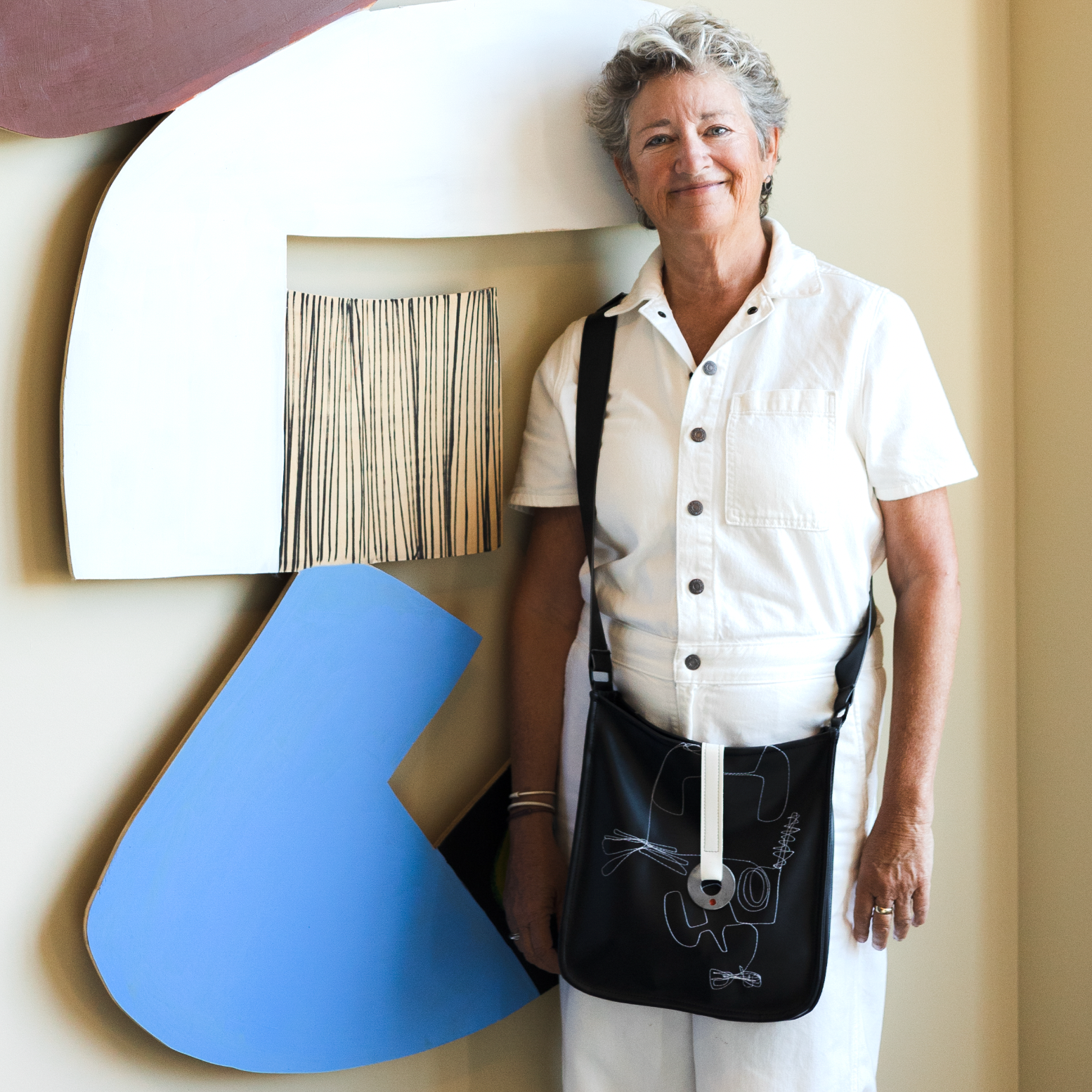 Mary Flannery, the artist and founder of O dot standing in front of her art